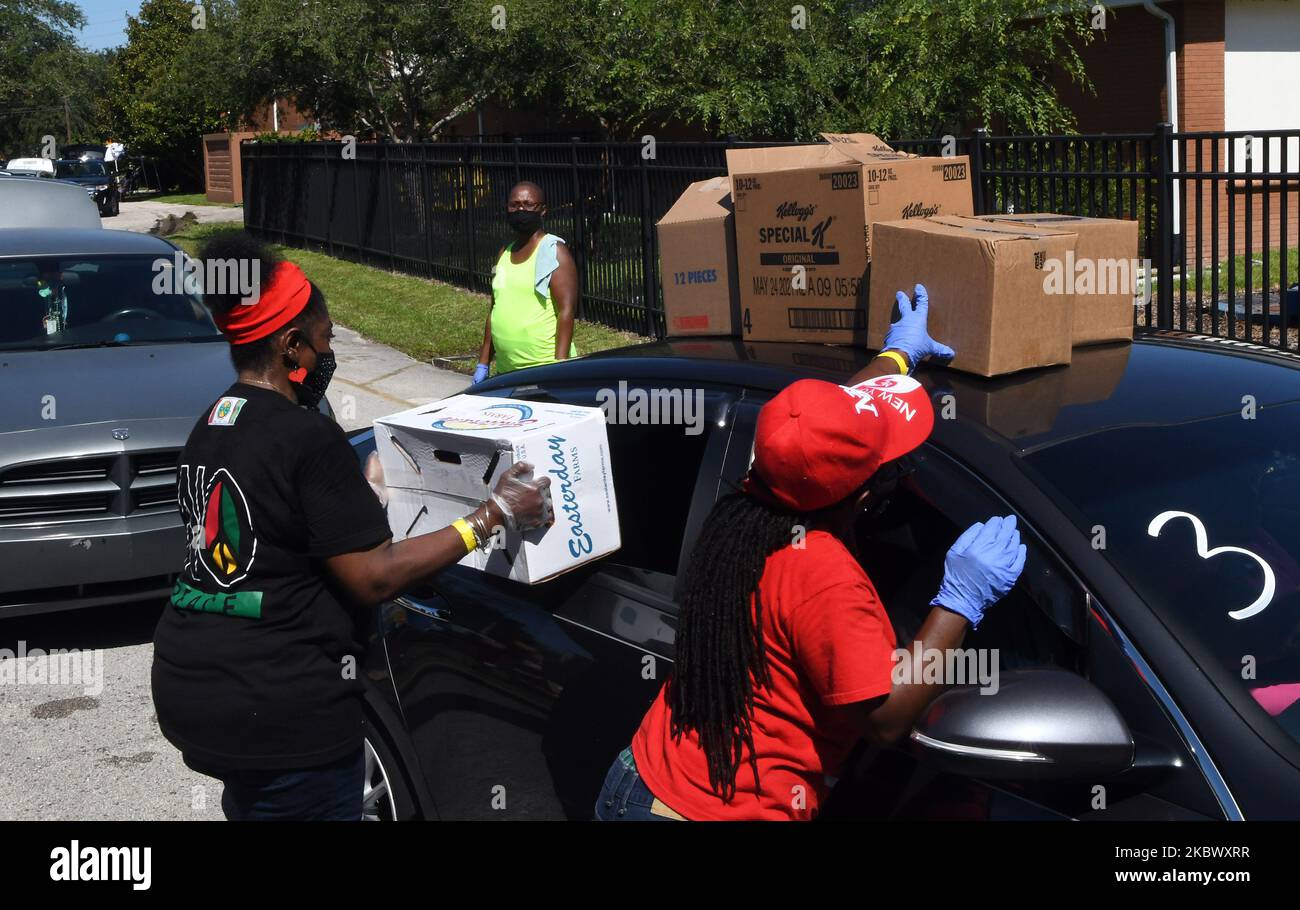Volunteers place boxes of food from the Second Harvest Food Bank of Central Florida on the roof of a car at a food distribution event at Carter Tabernacle Christian Methodist Episcopal Church on August 8, 2020 in Orlando, Florida. Food Banks in the Orlando area face continued demand as unemployment due to the COVID-19 pandemic persists. (Photo by Paul Hennessy/NurPhoto) Stock Photo