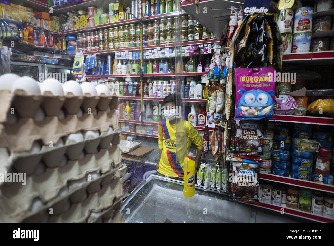 An Iranian worker wearing a protective face mask while standing at a local supermarket in Tehran’s business district, following the new coronavirus (COVID-19) outbreak in Iran. (Photo by Morteza Nikoubazl/NurPhoto) Stock Photo