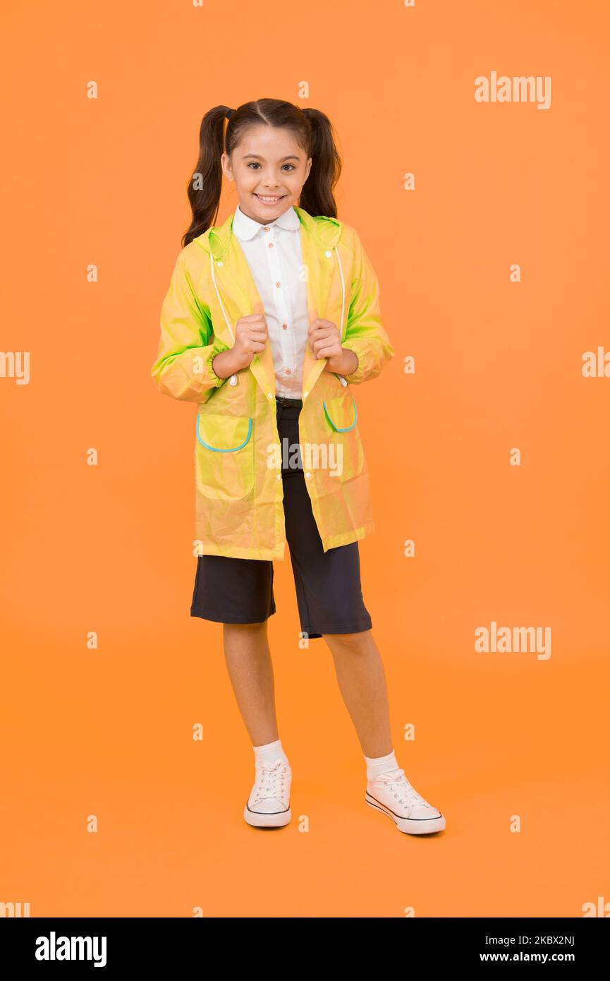 Cute schoolgirl feel protected. Happy schoolgirl wear raincoat. Invest in durable kids rainwear to keep children out in fresh air. Waterproof concept Stock Photo