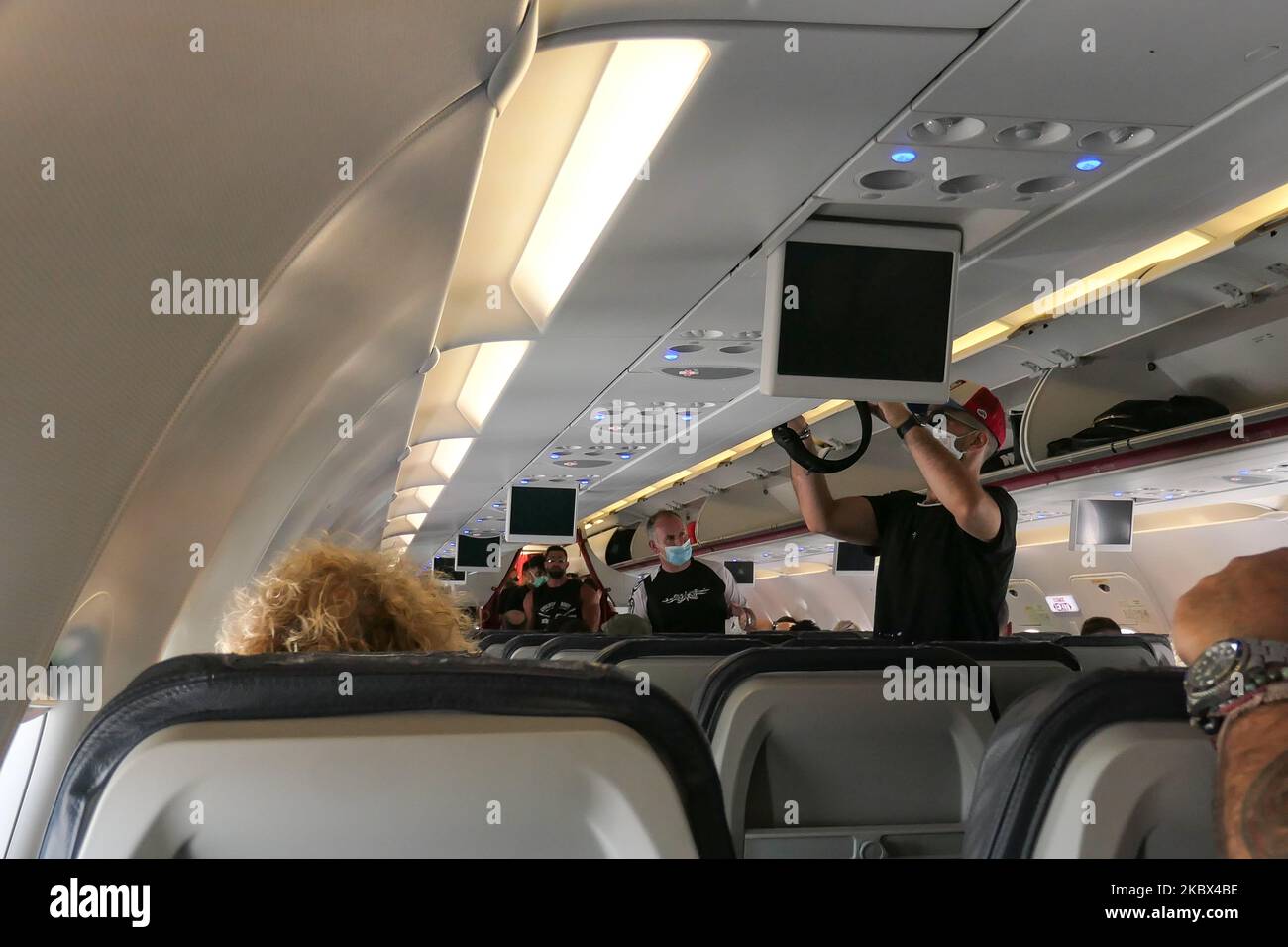 Passengers with facemasks boarding inside an Aegean Airbus A320. Flying