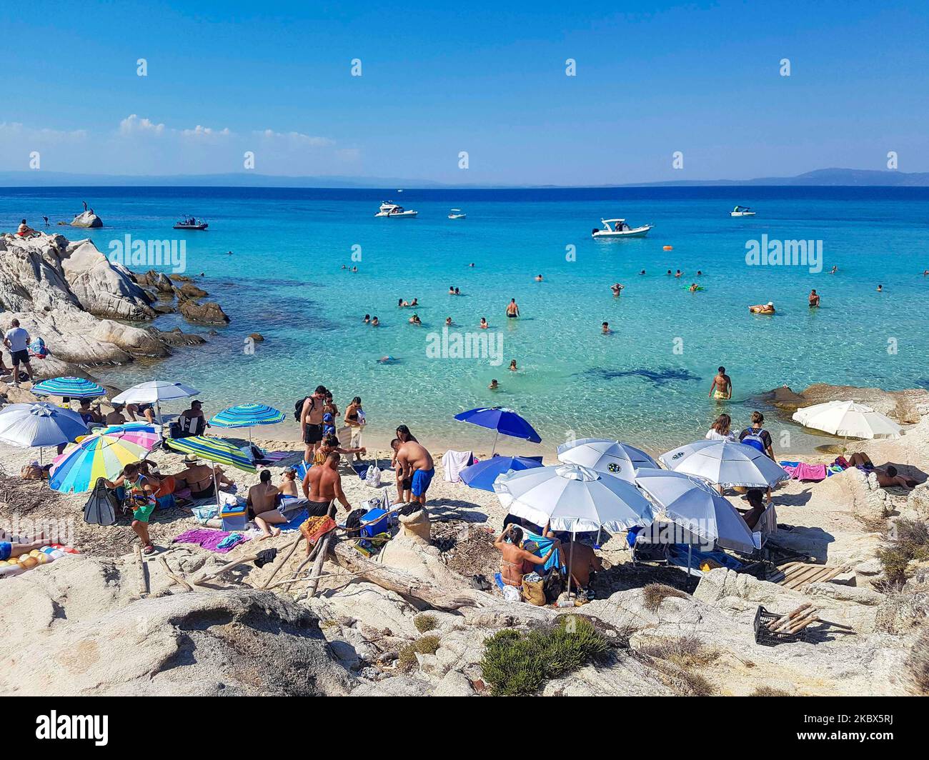 fun tropical activity nudists People have fun at the beach in Greece as they are relaxing under the shadow of the umbrellas or pine trees, swimming in the tropical exotic waters, sunbathing on the rocks and