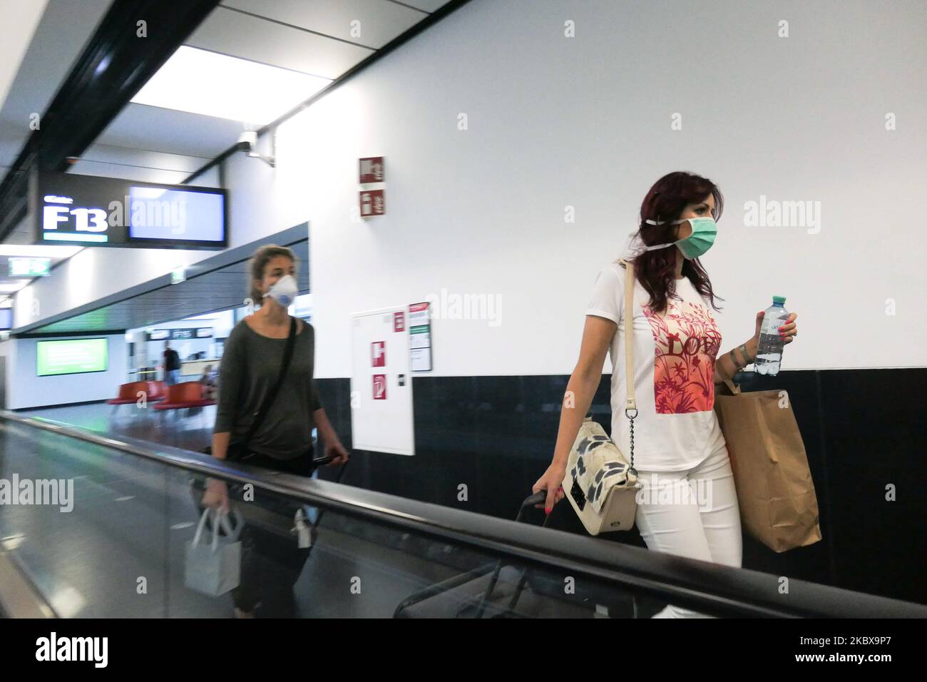 Passengers wearing facemasks, gloves and safety measures are seen at