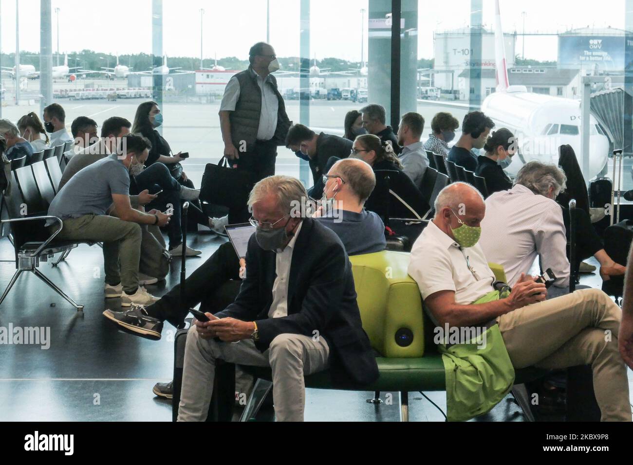 Passengers wearing facemasks, gloves and safety measures are seen at the terminal, F Gates area of Vienna International Airport VIE LOWW - Flughafen Wien-Schwechat, on July 15, 2020 serving the Austrian Capital but also Bratislava as it is 55km away from the Slovak city during the Covid-19 Coronavirus pandemic era with social distancing measures and disinfecting hand sanitizer everywhere afther the lockdown period. On July 1, Austria issues travel warning for six Balkan states countries, Serbia, Montenegro, Bosnia Herzegovina, North Macedonia, Albania and Kosovo. Passengers traveling from thos Stock Photo