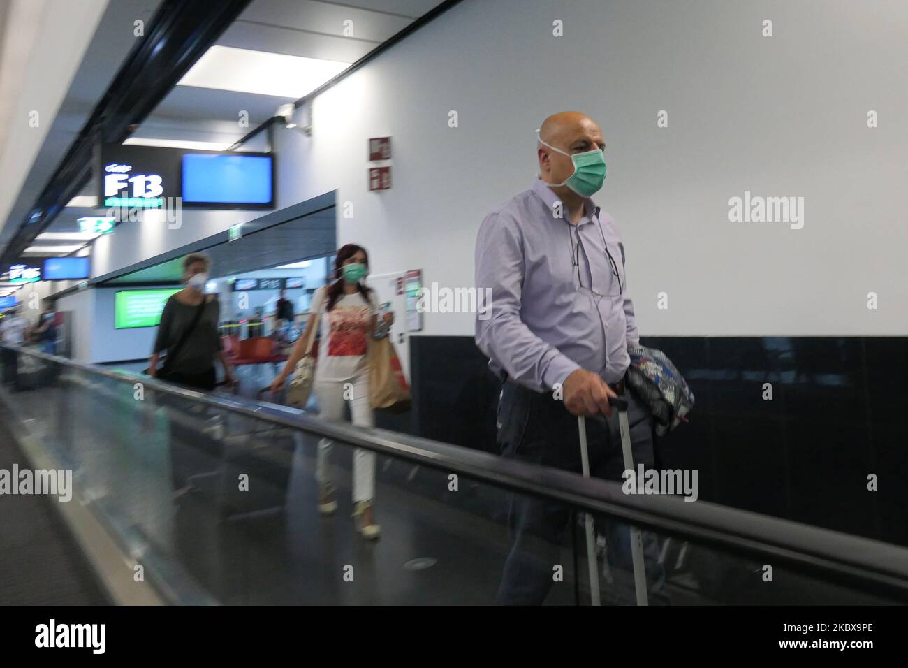 Passengers wearing facemasks, gloves and safety measures are seen at