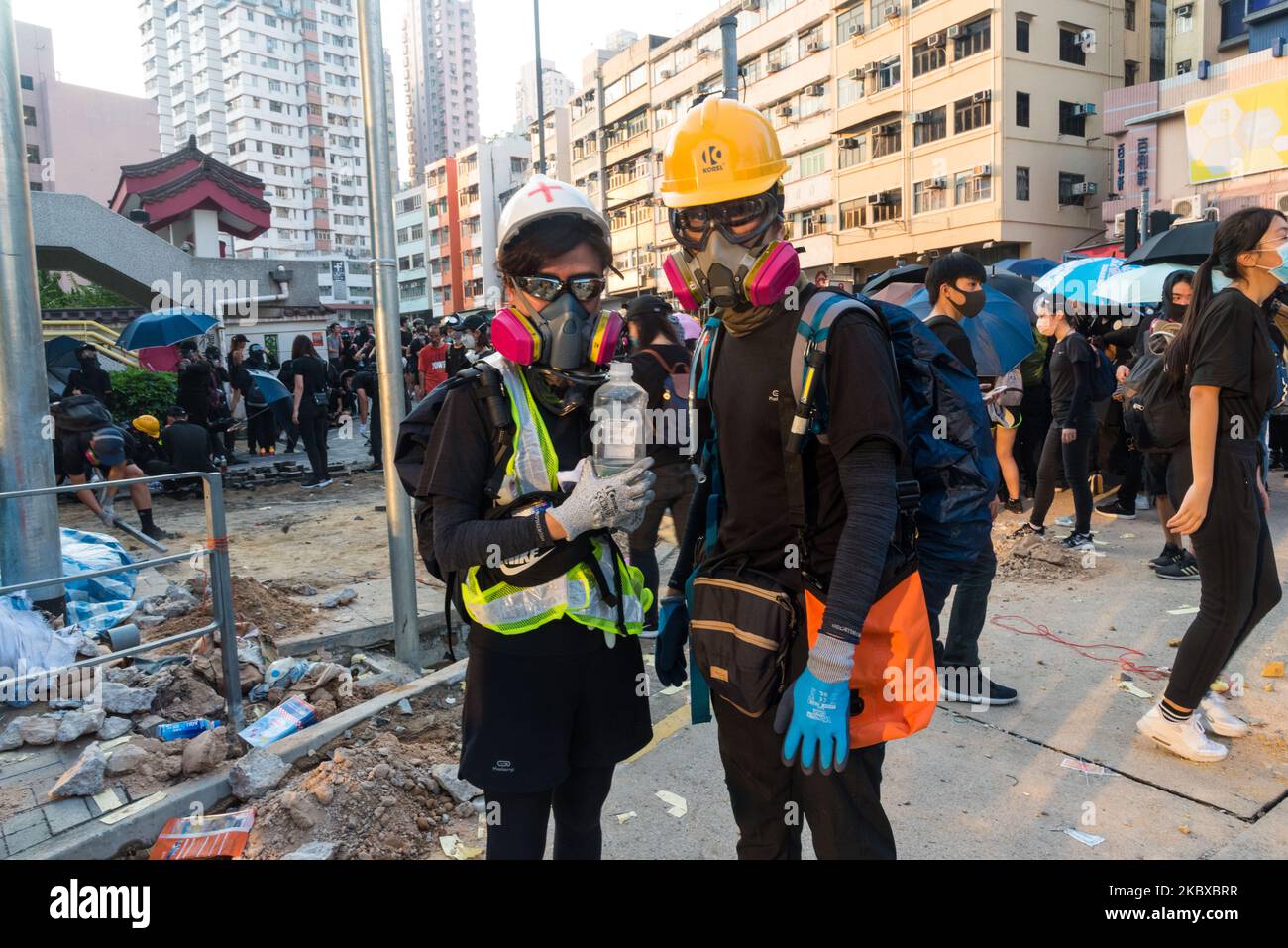 Two first aiders stand ready for action near the frontliners of Wong Tai Sin during a lull in the action in Hong Kong, China, on October 1, 2019. (Photo by Marc Fernandes/NurPhoto) Stock Photo
