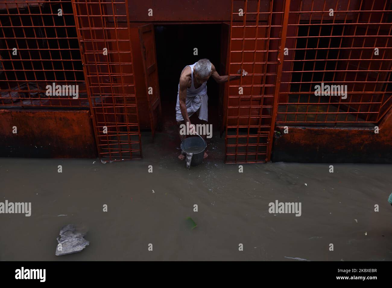 An old man is clearing the water away from his house, the Ganges water flowed into during the high tide and the street is waterlogged in Kalighat area, Kolkata, India, on August 22, 2020. Many parts of Kolkata became waterlogged due to sudden and heavy continuous rainfall, the high tide which also caused the rise in the water level in the Ganges. The Meteorological department on forecast heavy downpour in southern Bengal in the next few days. (Photo by Sukhomoy Sen/NurPhoto) Stock Photo