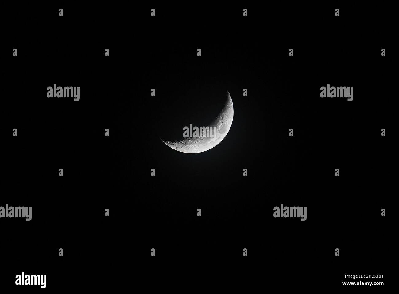 A crescent moon (waxing crescent) on the night sky above Bangkok on