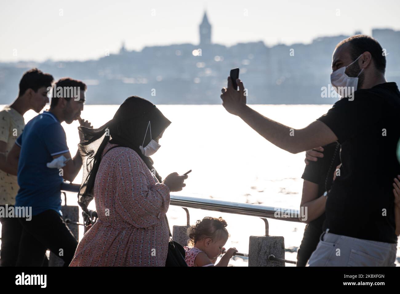 On 23 August, 2020, citizens of Turkey's largest city, Istanbul, on August 24, 2020, went about leisure activities on a Sunday afternoon and pursued daily routines while wearing face masks, as required by the Turkish government to reduce the spread of Covid-19. Pictured above, pedestrians take selfies while wearing face masks in Uskudar, Istanbul. (Photo by Diego Cupolo/NurPhoto) Stock Photo