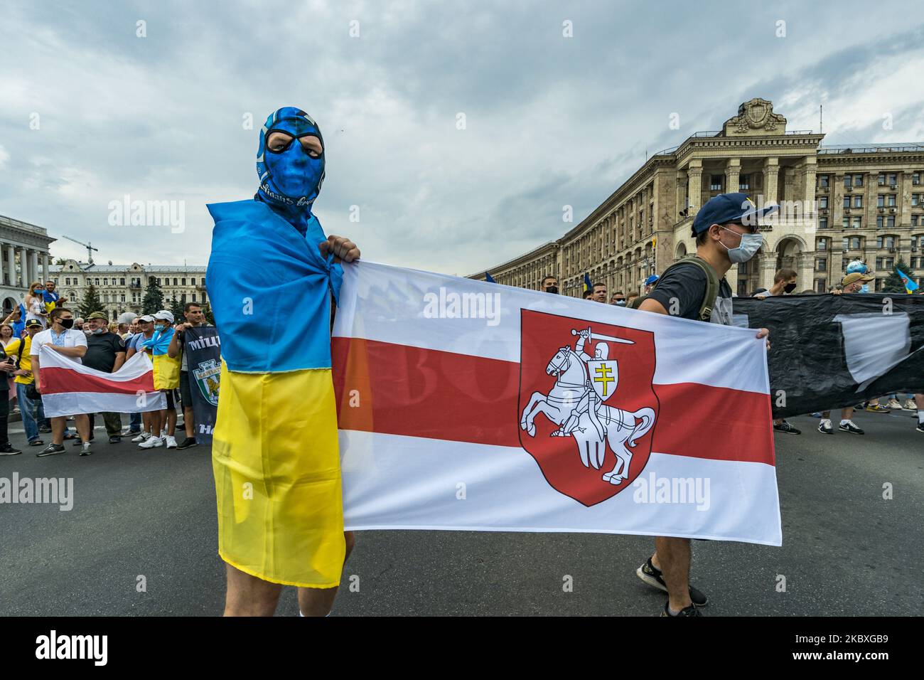 Masked protester holds an old Belarus flag in support of the protests against the current Belarus government, during the celebrations of the Independence Day in Kiev, Ukraine. (Photo by Celestino Arce/NurPhoto) Stock Photo