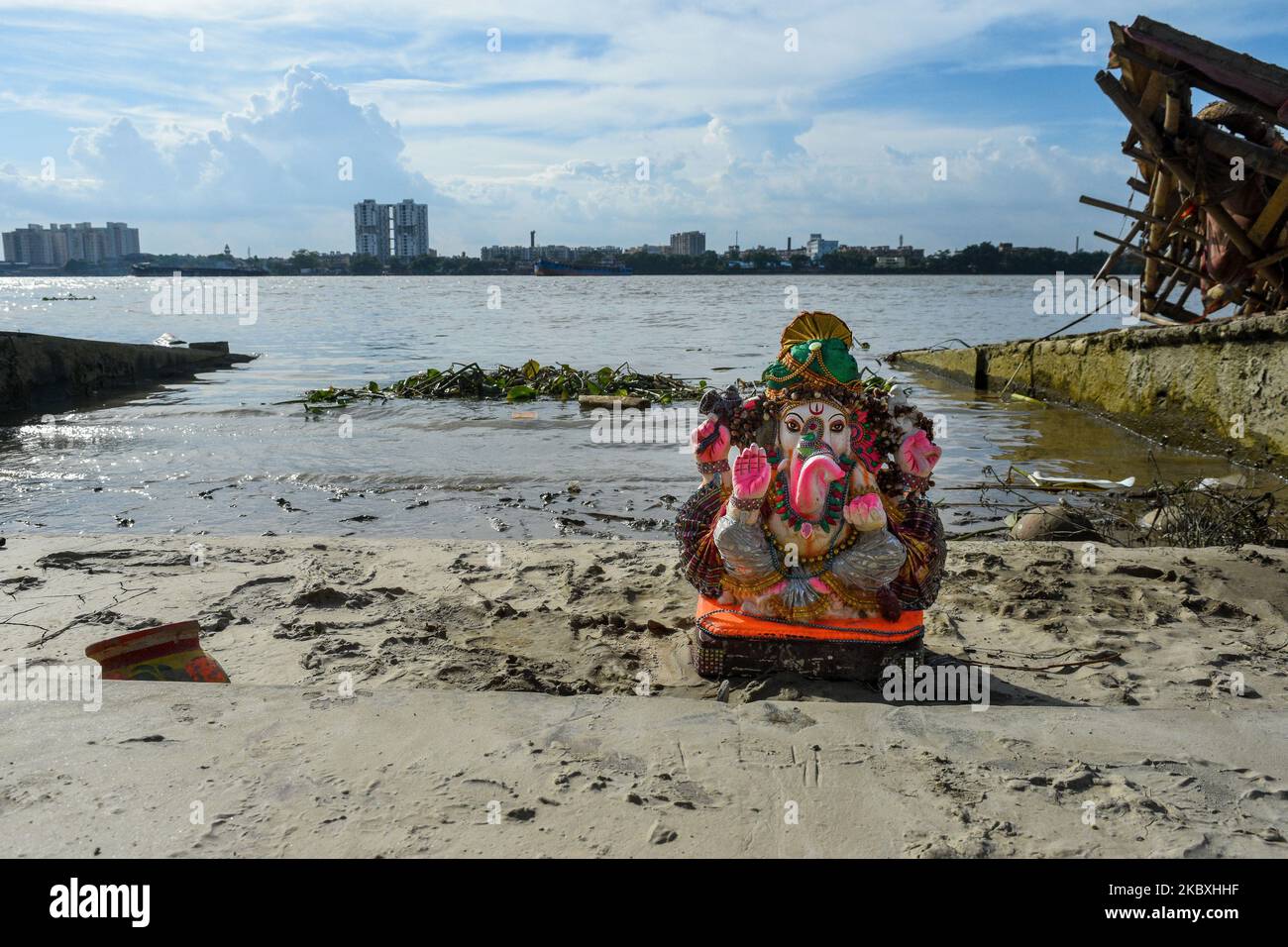 An idol of Ganesha sits at a bank of river Ganges after immersion.The ...