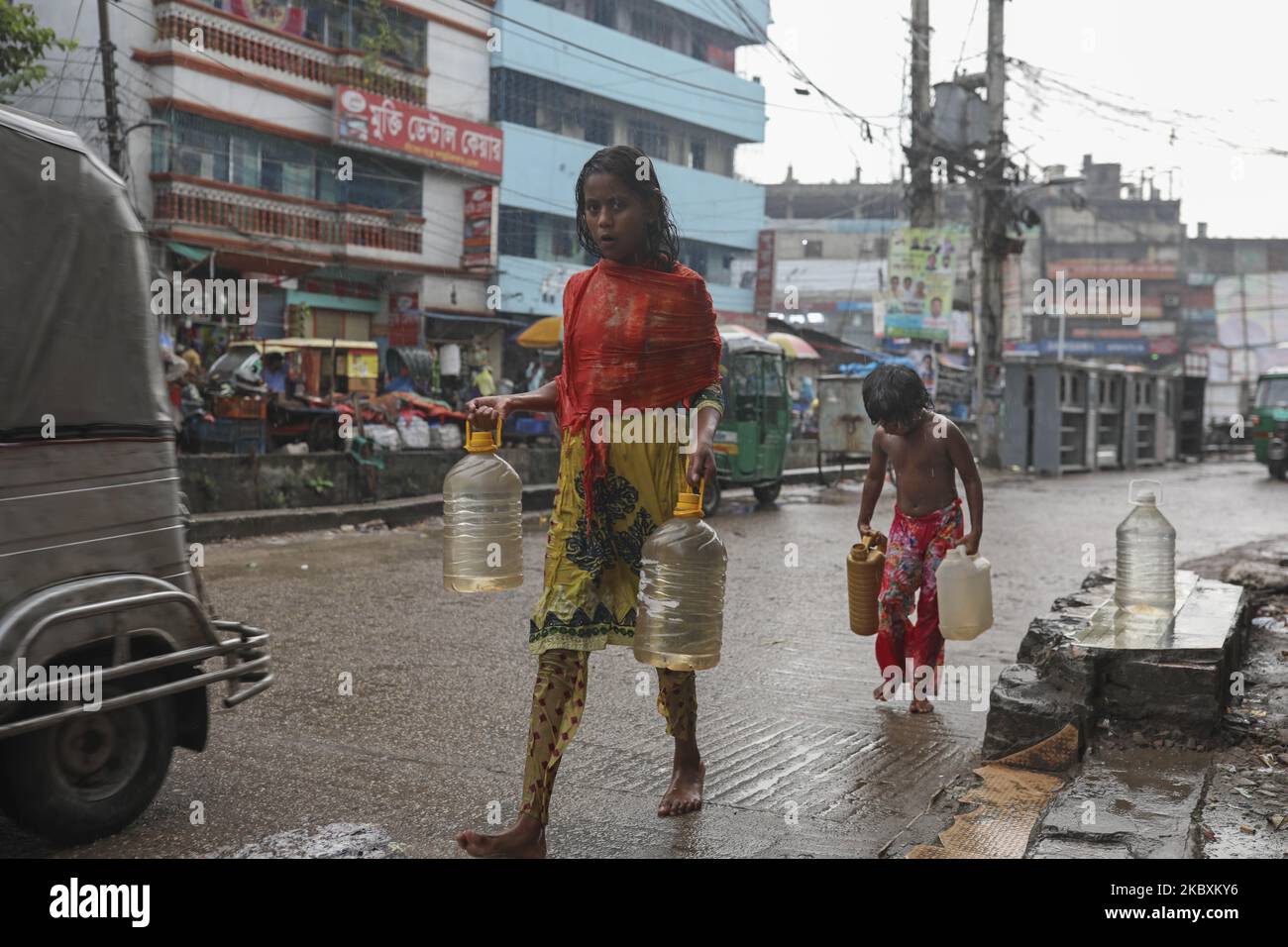 Children are collecting drinking water in a rainy day in Dhaka Bangladesh on August 27, 2020 (Photo by Kazi Salahuddin Razu/NurPhoto) Stock Photo