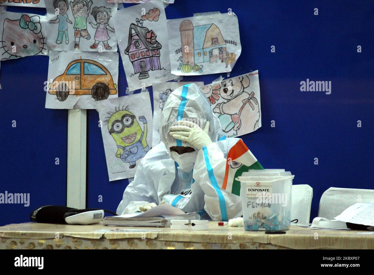 A doctor covered in Personal Protective Equipment (PPE) kit, examines the patient inside female ward at Covid care facility inside Commonwealth Games Village Sports Complex, in New Delhi, India on August 28, 2020. India's Covid tally rose to 3,387,500 with 77,266 new cases in 24 hours. The death toll was recorded at 61,529, as per latest figures released by the Ministry of Health and Family Welfare. (Photo by Mayank Makhija/NurPhoto) Stock Photo