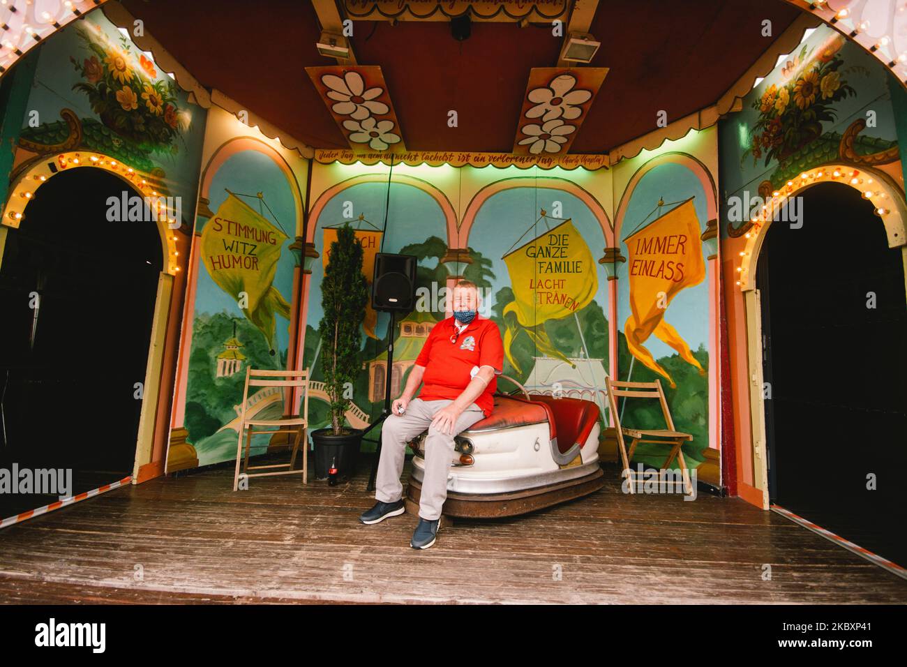 A vendor with face mask poses for portrait during the first day of historical fun fair opening