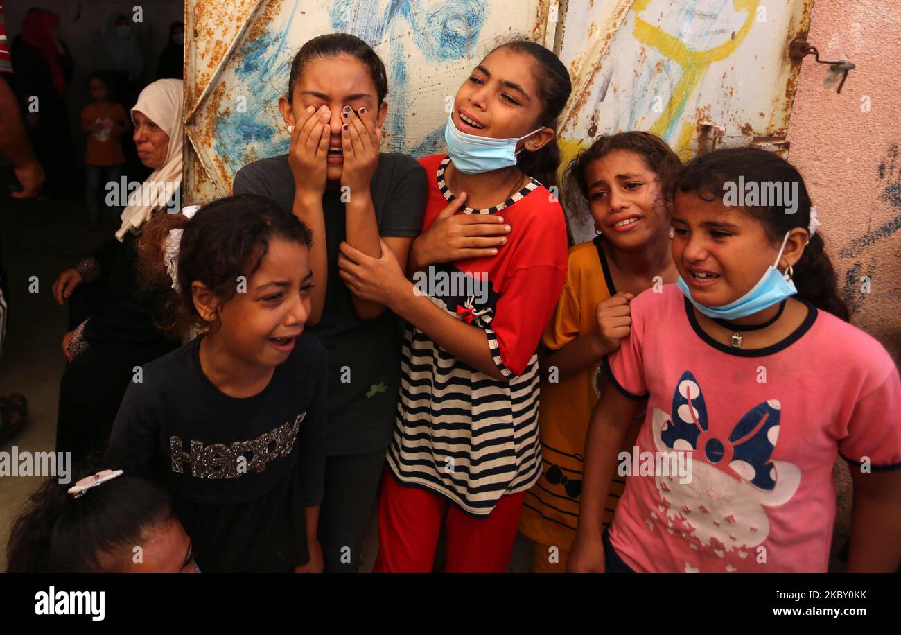Palestinians mourn during the funeral of three children who were killed ...