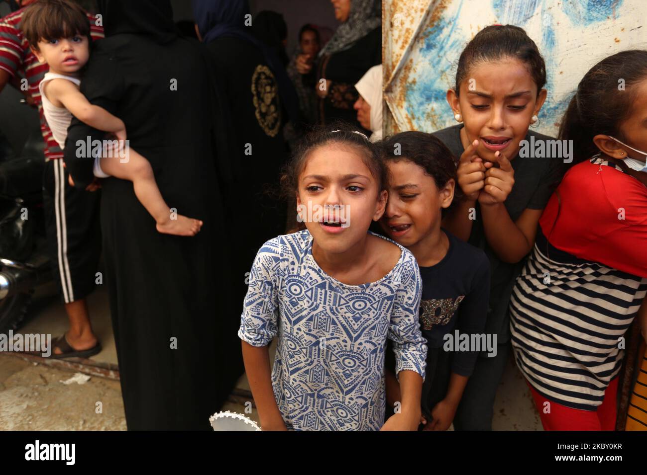 Palestinians mourn during the funeral of three children who were killed ...