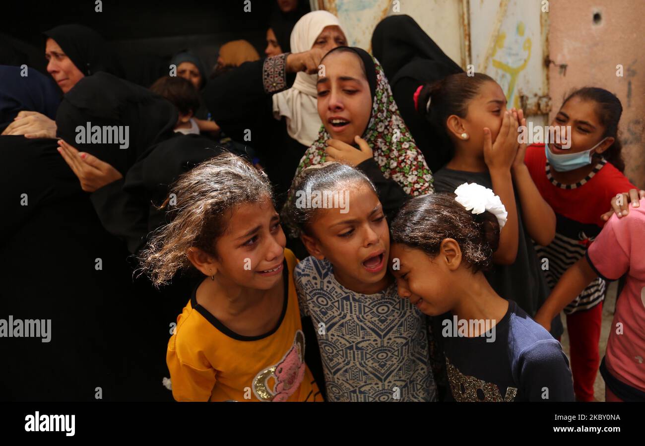 Palestinians mourn during the funeral of three children who were killed ...