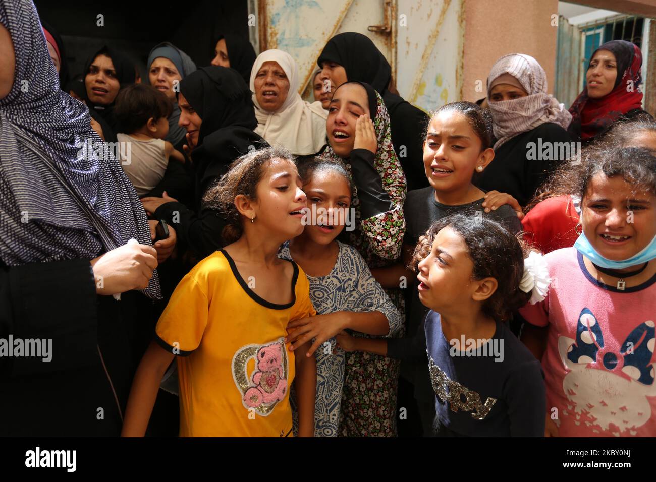 Palestinians mourn during the funeral of three children who were killed ...