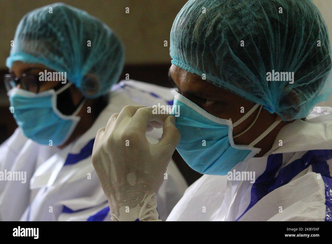 A healthcare worker wearing personal protective equipment (PPE) waits ...