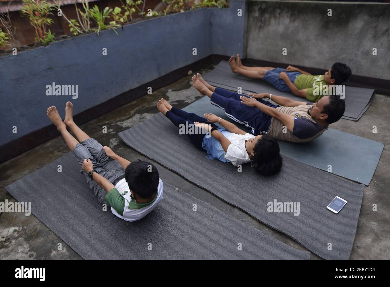 RAJMAN MAHARJAN a Yoga Practitioner along with his family members practicing Yoga Positions in the roof of house after the three district administrations have enforced prohibitory order lockdown in the Kathmandu valley due to rapid increase in the number of COVID-19 cases at Kirtipur, Kathmandu, Nepal on Wednesday, September 02, 2020. (Photo by Narayan Maharjan/NurPhoto) Stock Photo