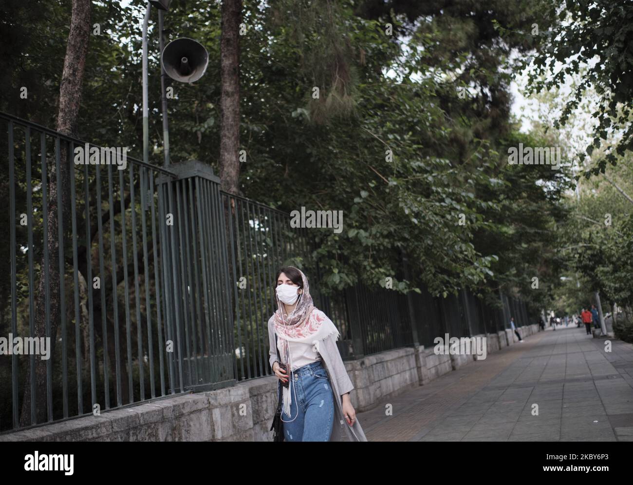 An Iranian woman wearing a protective face mask walks along an avenue in Tehran’s business district amid the new coronavirus (COVID-19) disease outbreak in Iran, on July 5, 2020. (Photo by Morteza Nikoubazl/NurPhoto) Stock Photo