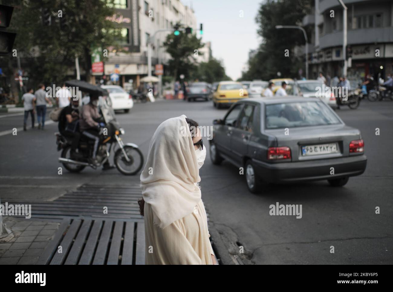 An Iranian woman wearing a protective face mask stands on a street-side in Tehran’s business district amid the new coronavirus (COVID-19) disease outbreak in Iran, on July 5, 2020. (Photo by Morteza Nikoubazl/NurPhoto) Stock Photo