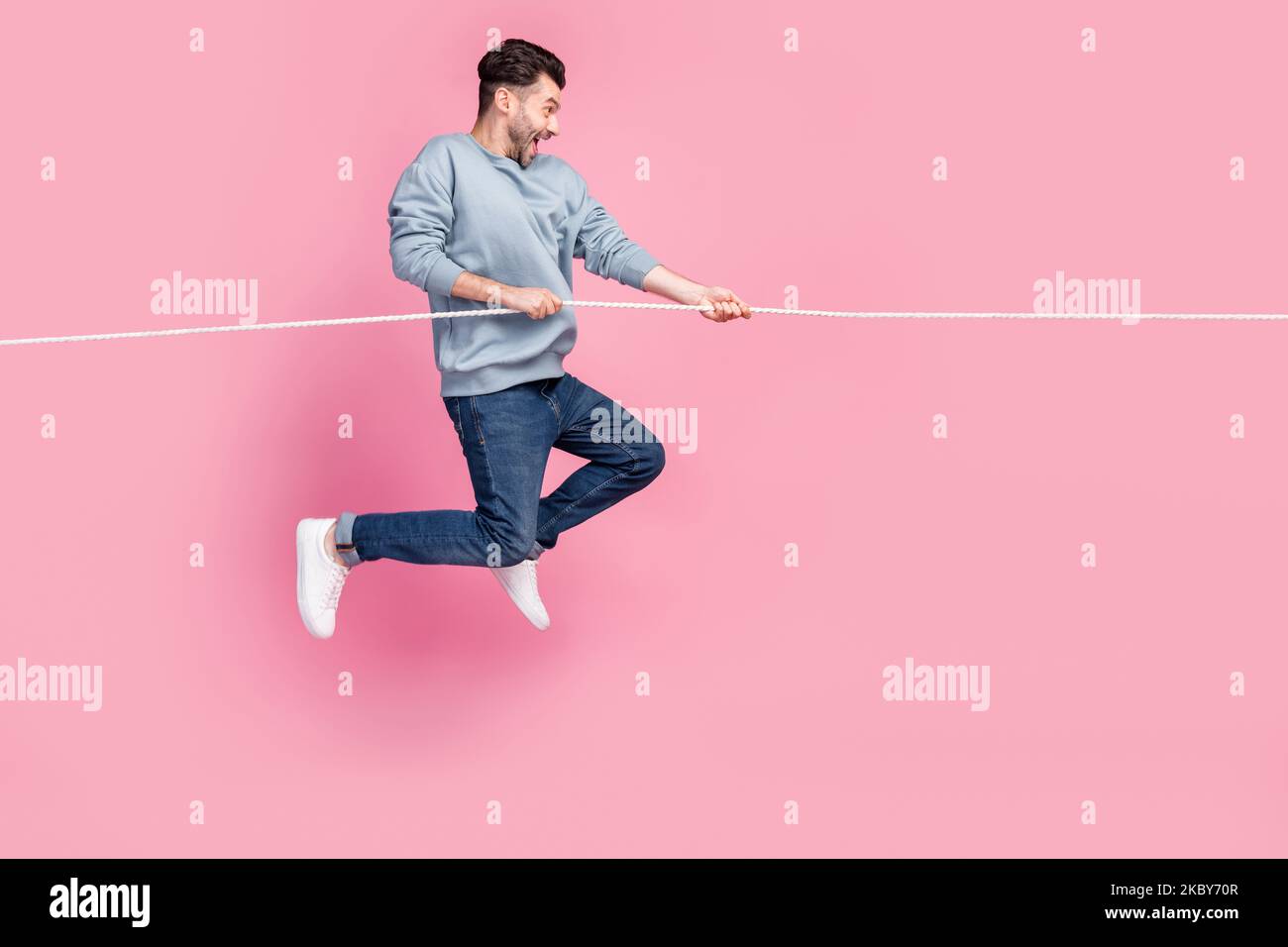 Profile side photo of determined guy jump pull string incredible ...