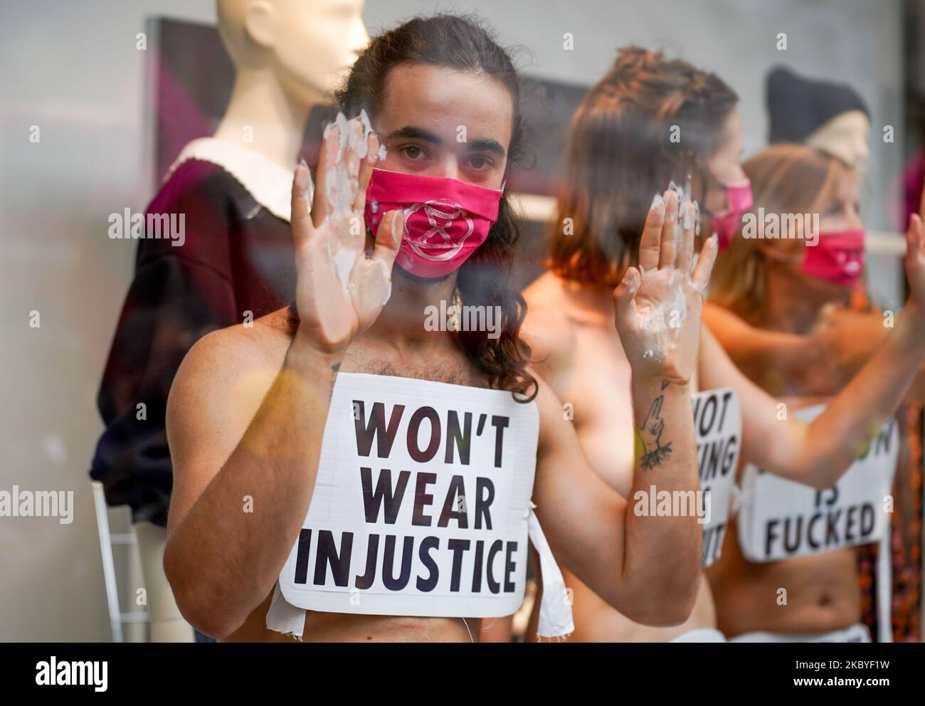 Members of the Extinction Rebellion environmental campaign group stage a protest inside a shop window to protest against fashion industry in H&M at Oxford Street in central London 9 September 2020 (Photo by Giannis Alexopoulos/NurPhoto) Stock Photo