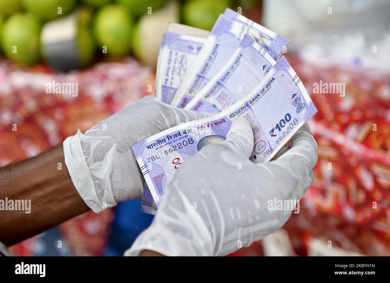 A man counts currency in front of a fruit market in Kolkata, India, 10 September, 2020. India's retail inflation likely stayed above Reserve Bank Of India's medium-term target range in August for the fifth month as the supply disruptions kept food and fuel prices high according to an Indian media report. (Photo by Indranil Aditya/NurPhoto) Stock Photo