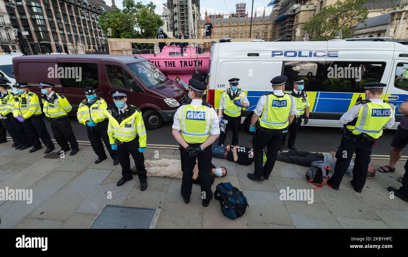 Activists from Extinction Rebellion lie on the ground after being ...