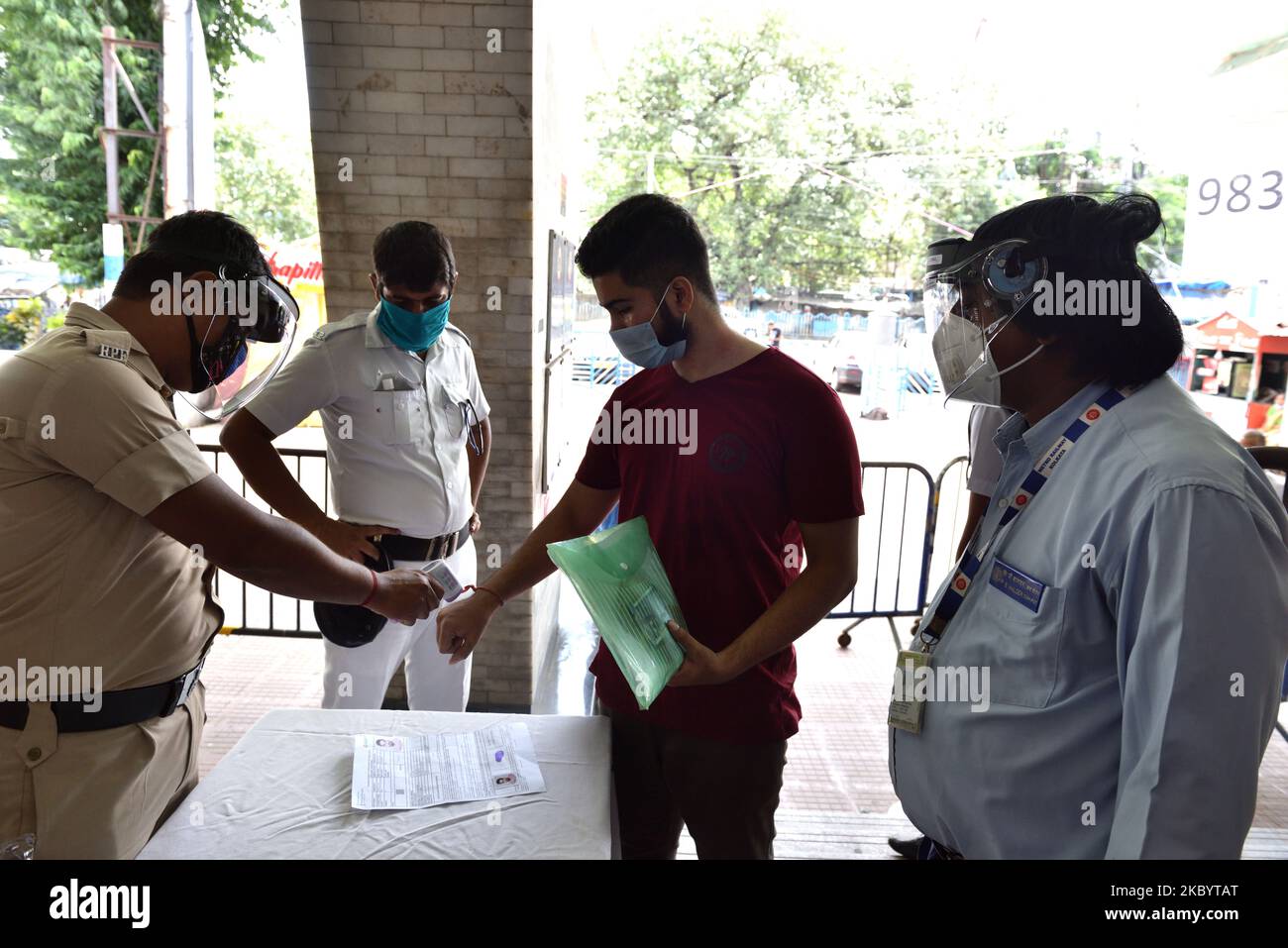 A RPF personnel wearing face shield and mask checks body temperature by a thermal screening device of NEET aspirant before entering into the metro station. In Kolkata, India, on September 13, 2020. (Photo by Sukhomoy Sen/NurPhoto) Stock Photo