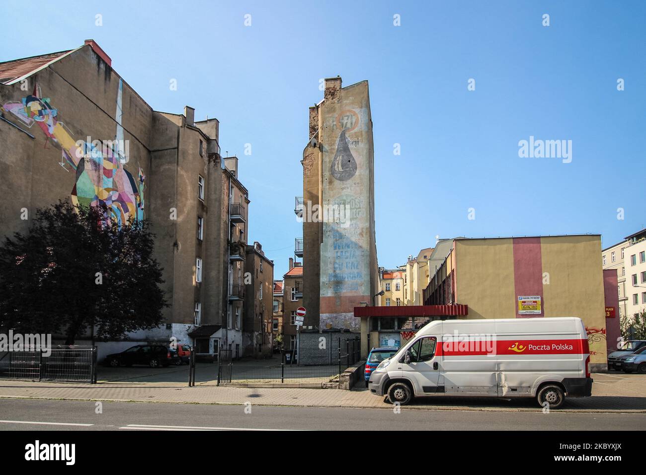 Polish Post (Poczta Polska) delivery van standing in front of communist era giant mural - commercial painted on the old tenement house wall is seen in Poznan, Poland on 11 September 2020 (Photo by Michal Fludra/NurPhoto) Stock Photo