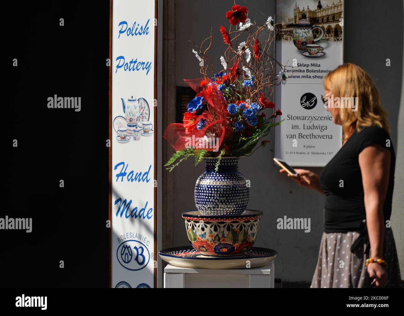 A woman walks by a shop with Polish pottery, in Krakow's Old Town. On September 15, 2020, in Krakow, Poland. (Photo by Artur Widak/NurPhoto) Stock Photo