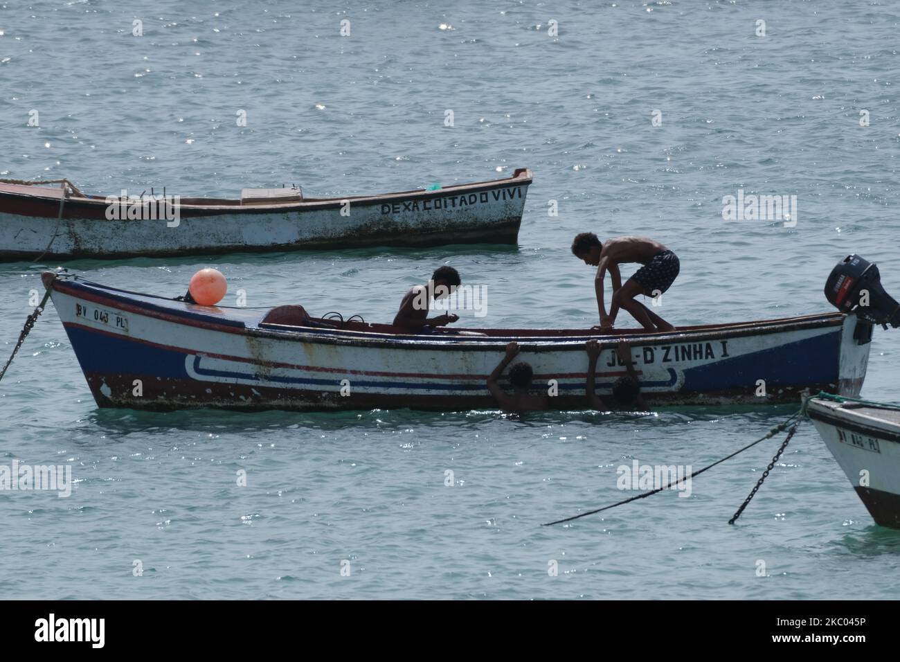 Four Kids Climbing And Sitting In A Boat In The Coast Of Sal Rei, Cabo 