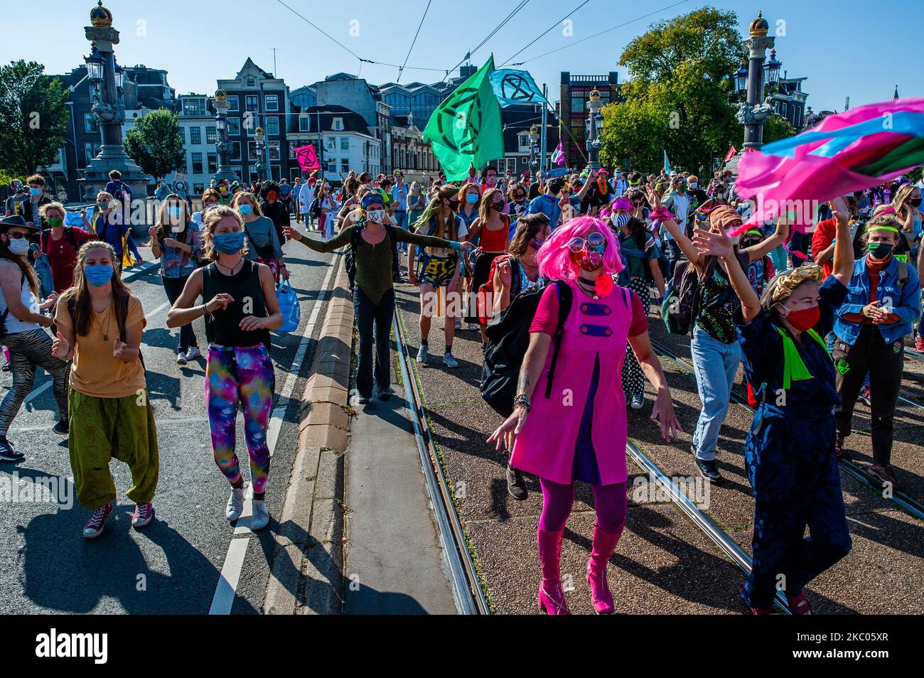 Protesters on September 19th, 2020 in Amsterdam, Netherlands. During the whole month, the climate activist group Extinction Rebellion in The Netherlands has planned a new campaign, with the name 'September Rebellion' to draw attention to the climate and ecological crisis. At the Museumplein, in Amsterdam, hundreds of XR activists danced to demand action against climate change in what protesters dubbed ''civil disco-bedience''. Activists waved flags and danced to songs including the Bee Gees' 1977 hit, Stayin' Alive. After the Museumplein the activists blocked for a few minutes one of the most  Stock Photo