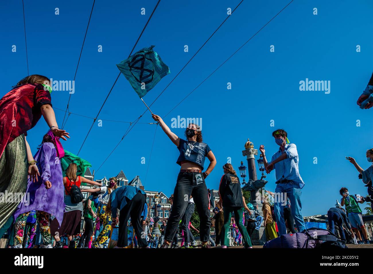 Protesters on September 19th, 2020 in Amsterdam, Netherlands. During the whole month, the climate activist group Extinction Rebellion in The Netherlands has planned a new campaign, with the name 'September Rebellion' to draw attention to the climate and ecological crisis. At the Museumplein, in Amsterdam, hundreds of XR activists danced to demand action against climate change in what protesters dubbed ''civil disco-bedience''. Activists waved flags and danced to songs including the Bee Gees' 1977 hit, Stayin' Alive. After the Museumplein the activists blocked for a few minutes one of the most  Stock Photo