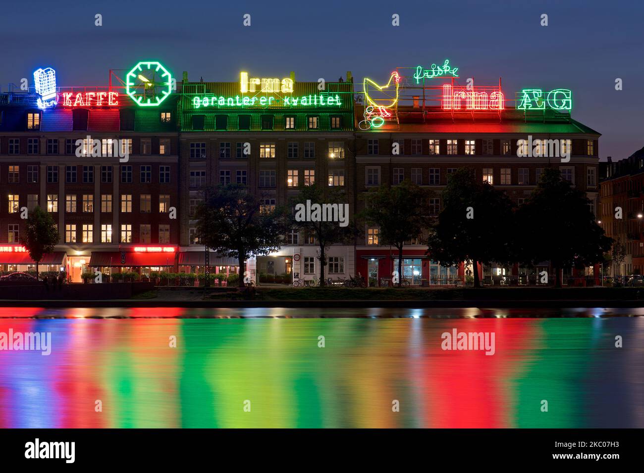 The neon lights of Irma-Honen reflected in the lake in Copenhagen, Denmark Stock Photo