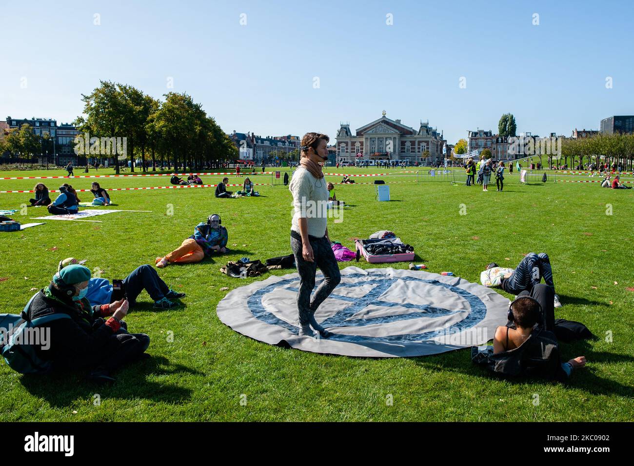 A woman is walking around the XR logo during a relaxation session, during the Extinction Rebellion camp located at the Museumplein, in Amsterdam, on September 19th, 2020. (Photo by Romy Arroyo Fernandez/NurPhoto) Stock Photo