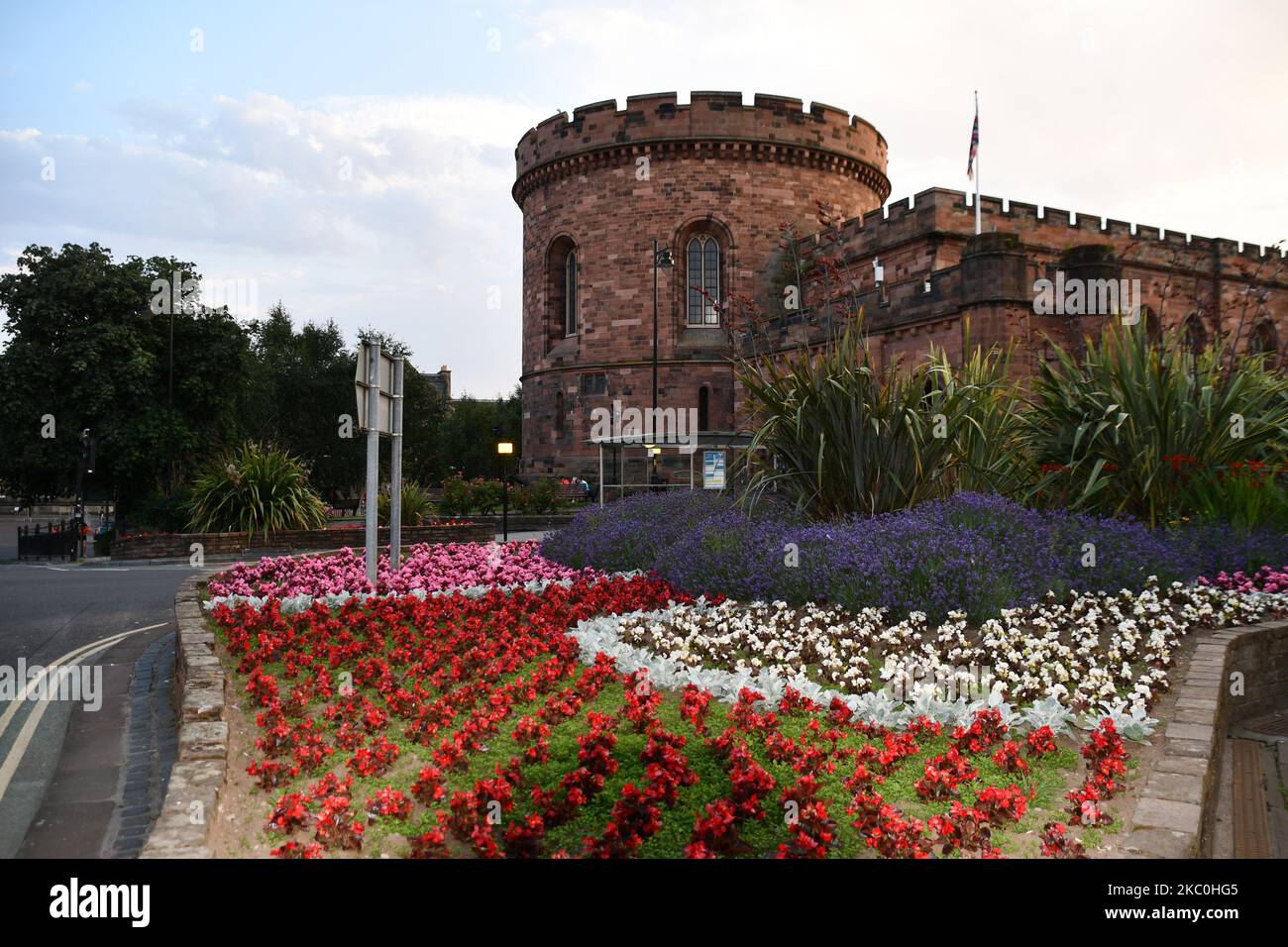 Western tower of Carlisle Citadel a former medieval fortress on English Street with a stunning floral display in the foreground. The western tower was Stock Photo