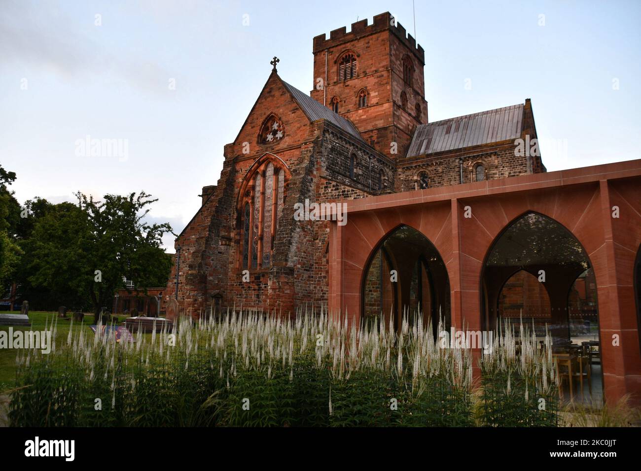 Carlisle Cathedral, with its recently added Fratry ( refectory) in the foreground, built from local red sandstone glowing in the early evening sun. Fi Stock Photo
