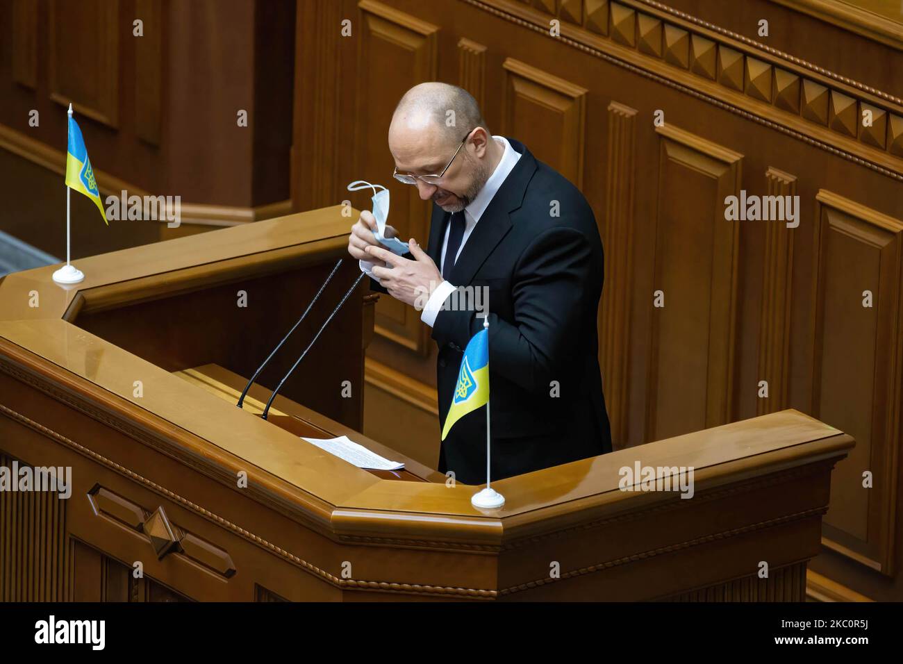 Prime Minister of Ukraine Denys Shmyhal takes off his protective face ...