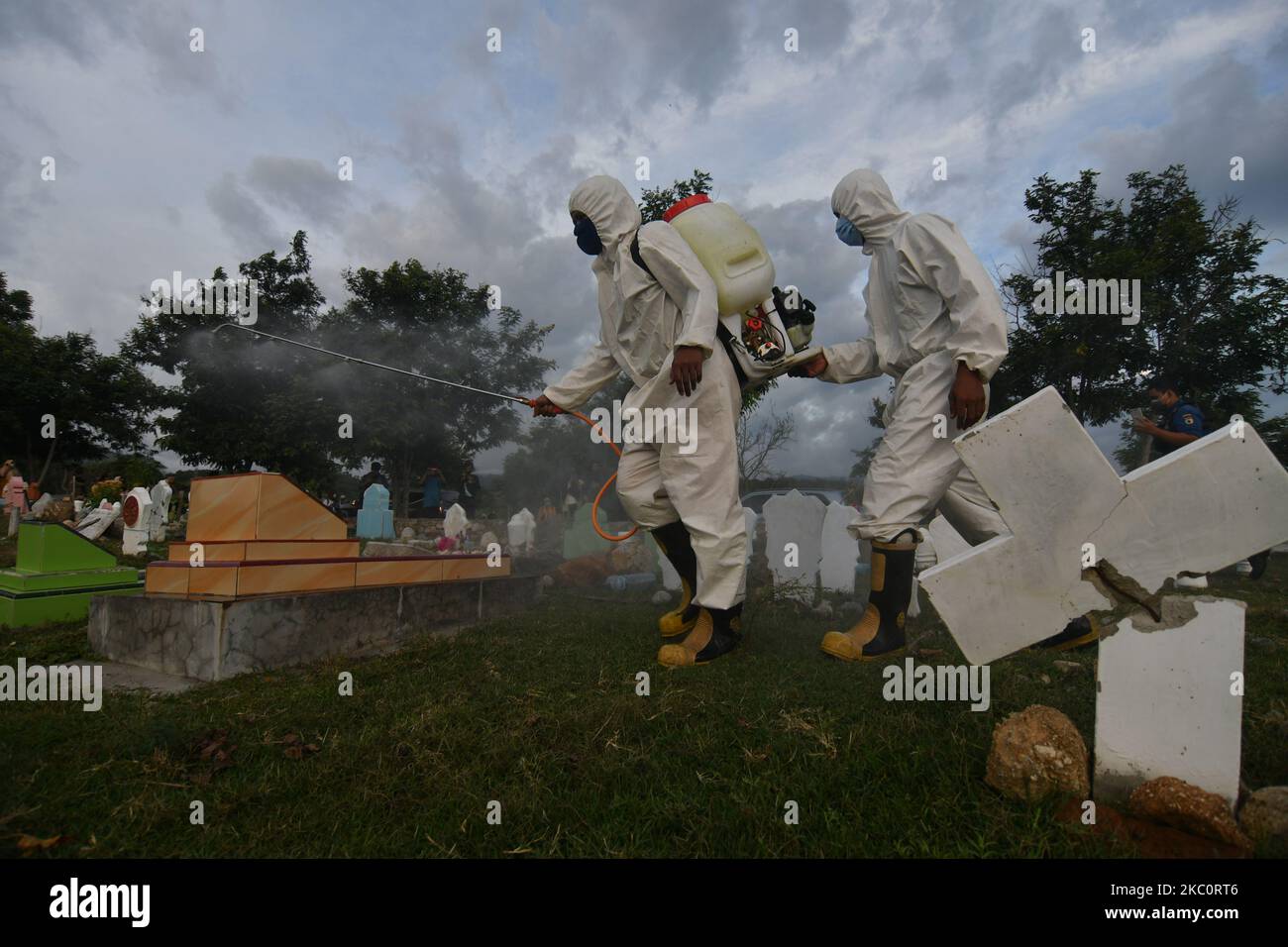 Officers spray disinfectant liquid to prevent the spread of COVID-19 in a burial area that is crowded with pilgrims, in Palu, Central Sulawesi Province, Indonesia, on September 28, 2020. Based on data from the Indonesian government until September 28, 2020 the number of people who were confirmed positive for COVID-19 in Indonesia reached 278,722 people and 206,870 people were declared cured and 10,473 people died. (Photo by Mohamad Hamzah/NurPhoto) Stock Photo