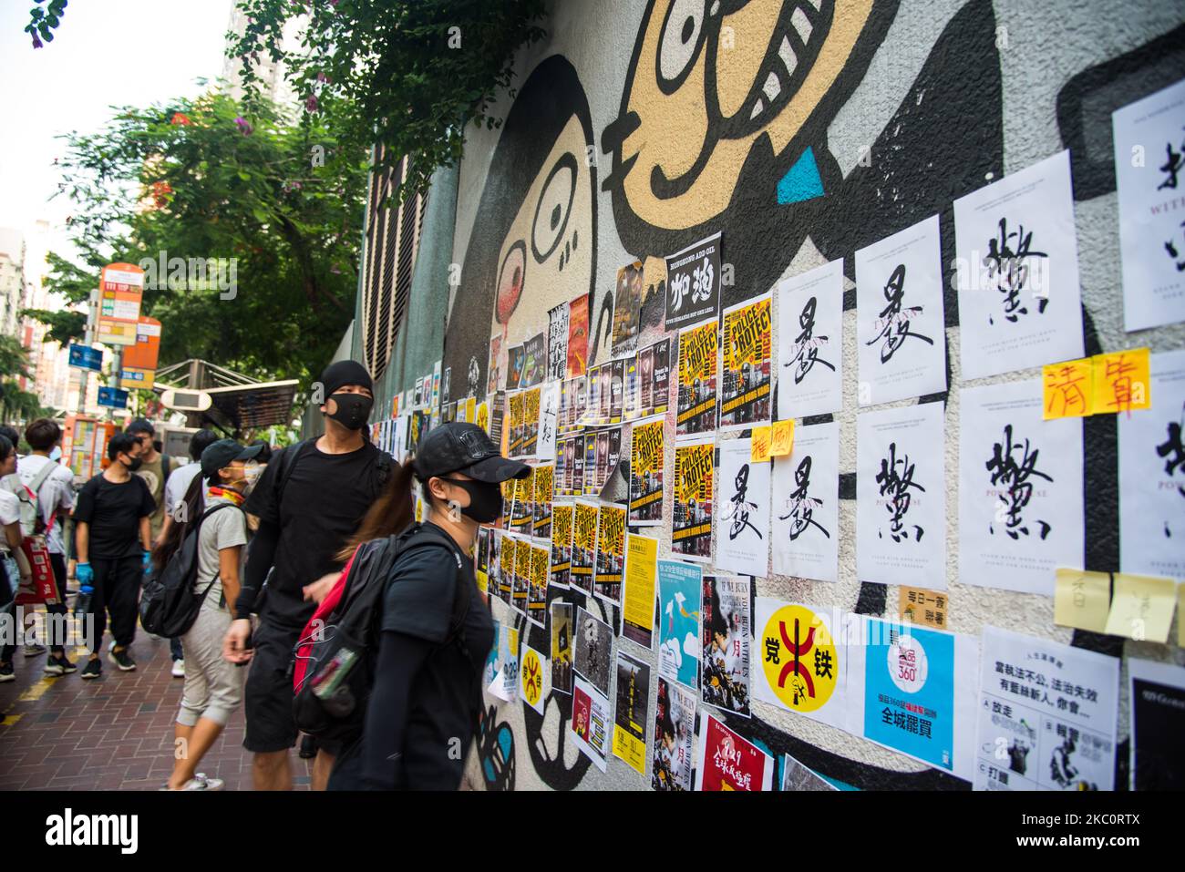 Masked protesters survey a Lennon Wall near Southorn Playground in Wanchai, Hong Kong, China, on 28 Sep 2019. (Photo by Marc Fernandes/NurPhoto) Stock Photo