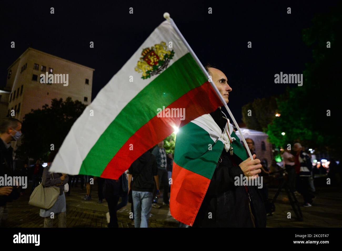 A protester holds a Bulgarian national flag on the 82nd day of anti-government protest in Sofia, in the Triangle of Power (the space between the buildings of the Presidency, the National Assembly and the Council of Ministers). For nearly three months people have been taking part in daily protests against corruption, demanding the resignation of the government of Boyko Borissov, in power since 2009. On Monday, September 28, 2020, in Sofia, Bulgaria. (Photo by Artur Widak/NurPhoto) Stock Photo