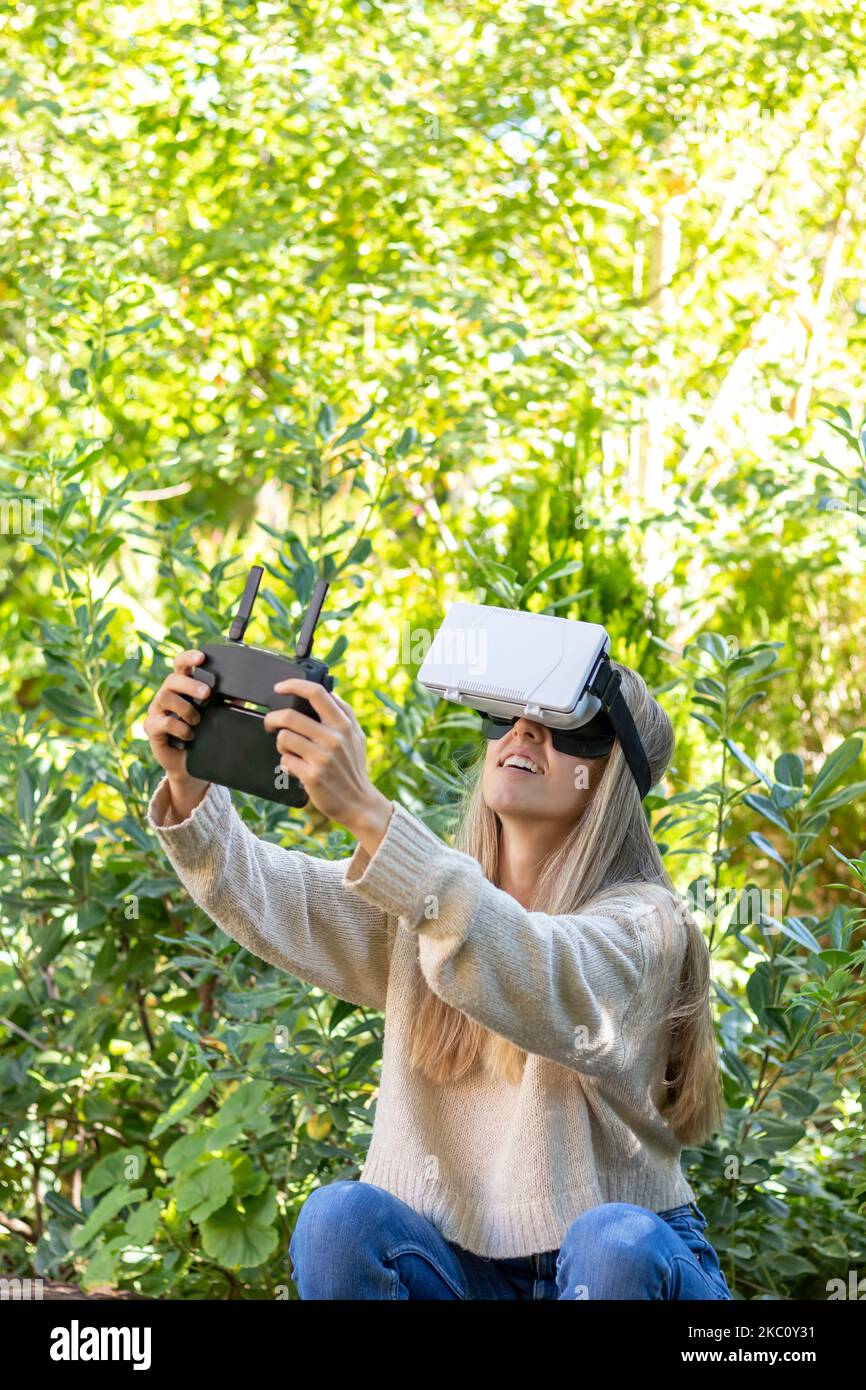 Vertical view of young excited while flying a drone in a natural
