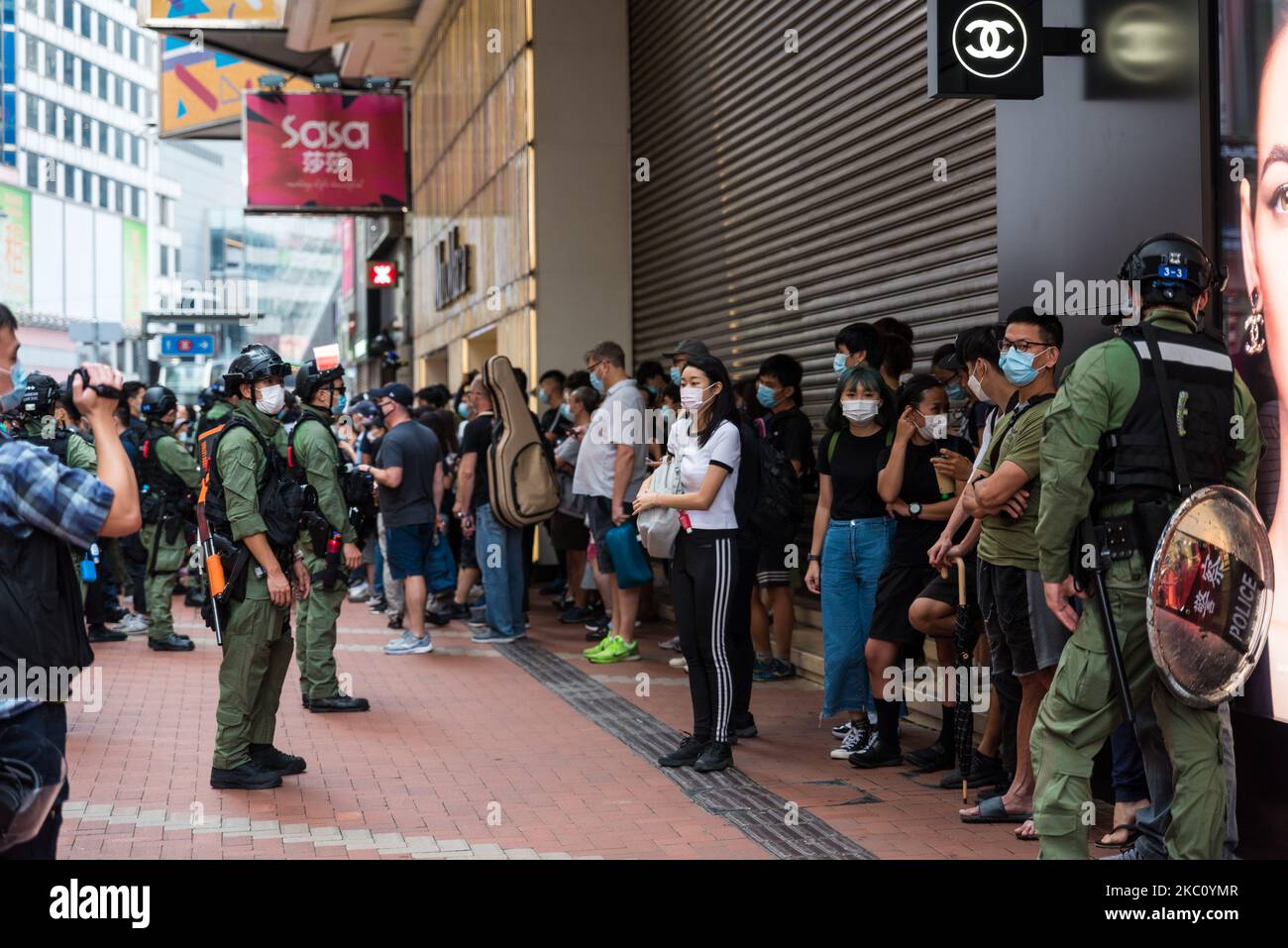 Protesters and bystanders are held inside a cordon for a stop and