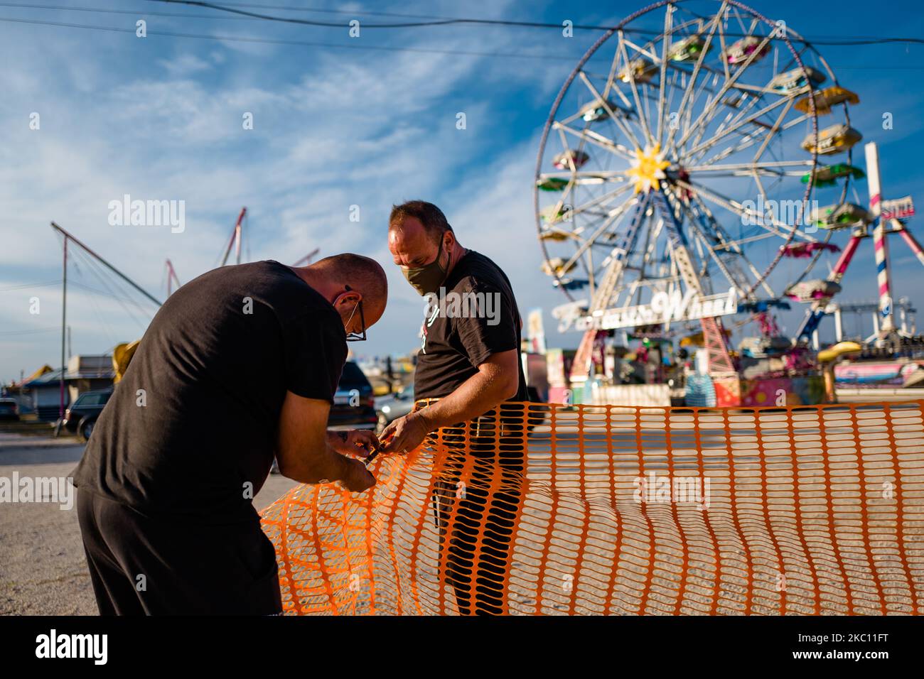 Workers work on the creation of the access gates to the Luna Park in Molfetta on 2 October 2020. Although in this period, there has been an increase in cases infected with Covid-19, from 1 October work began on the installation of the Luna Park in Molfetta. All attractions have anti Covid reports. Furthermore, they comply with all the regional provisions and ordinances of the President of the Emilia Region. The municipal authorization for the amusement park was signed for the period from 28 September to 25 October. (Photo by Davide Pischettola/NurPhoto) Stock Photo