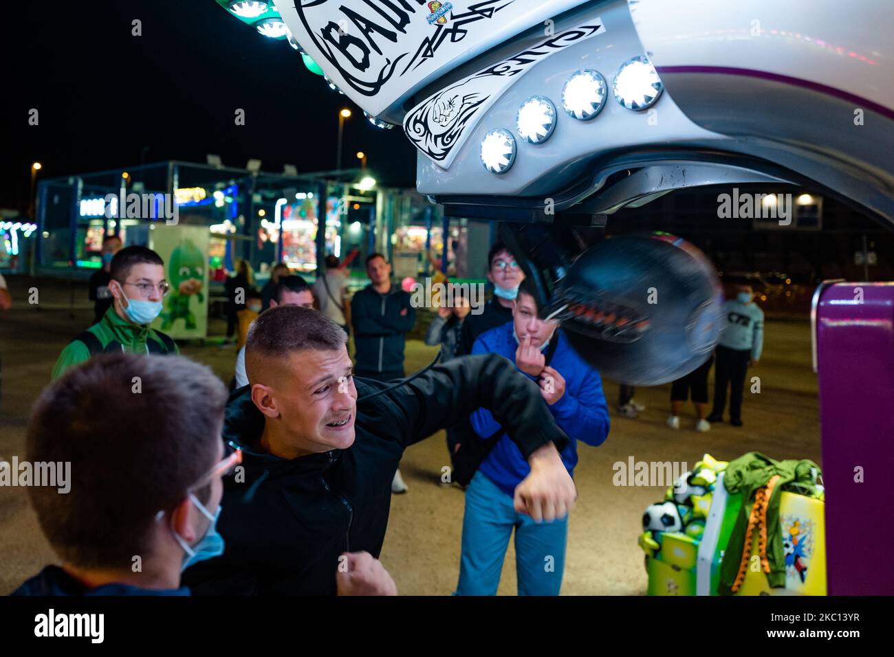 Boys play in an attraction of the Luna Park in Molfetta at Secca dei Pali on 3 October 2020. First day of opening of the Luna Park in Molfetta, in the period where the cases of Covid-19 infection are increasing. Even if at the entrance there is the temperature measurement, the obligation to wear a mask and to buy it there on the spot, many citizens propose a petition to close the attractions, because they are dangerous for everyone's health. (Photo by Davide Pischettola/NurPhoto) Stock Photo