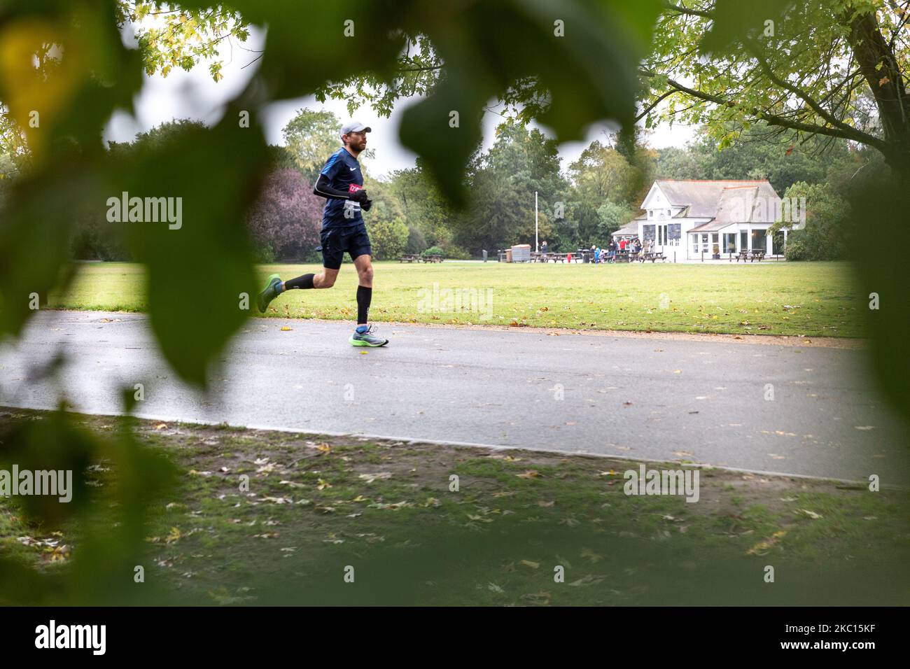 Puru Rai, a participant of Virgin Money Virtual London Marathon is seen running in cold rainy weather in Dulwich Park in South London, England on October 4, 2020. Due to Covid-19 pandemic, the London Marathon for the public was virtual. Participants run in locations of the choice, having a mobile application as a monitoring system. Family and friends often took shorter distances to support the runner. (Photo by Dominika Zarzycka/NurPhoto) Stock Photo