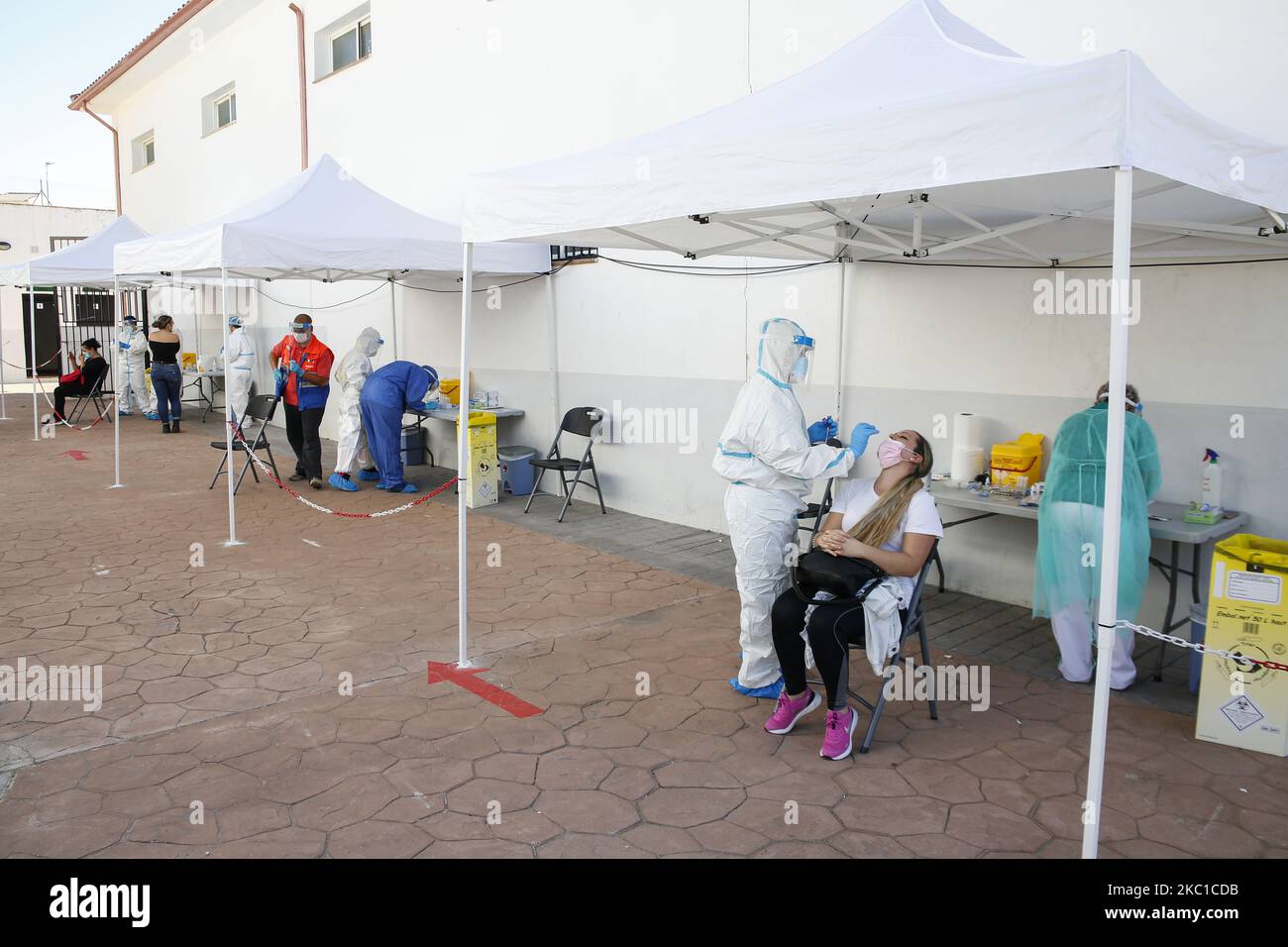 Health workers in Personal Protective Equipment (PPE) suits collect swab samples from people during the express COVID-19 testing in Alfacar, Granada, Spain on October 08, 2020. (Photo by Ãlex CÃ¡mara/NurPhoto) Stock Photo