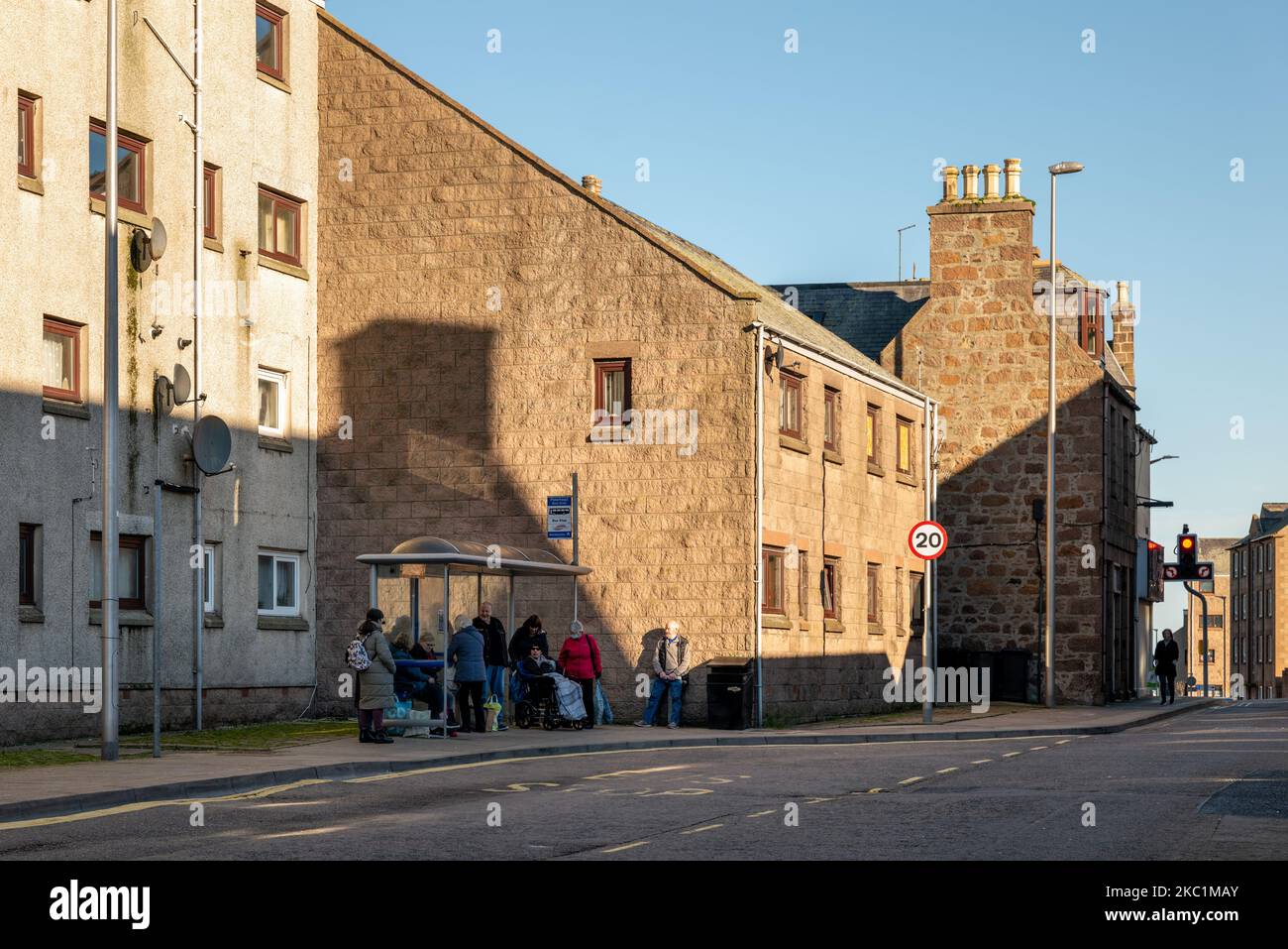 3 November 2022. Peterhead, Aberdeenshire, Scotland. This is people at a Bus Stop in Back Street, Peterhead waiting for the bus to arrive. Only one ma Stock Photo